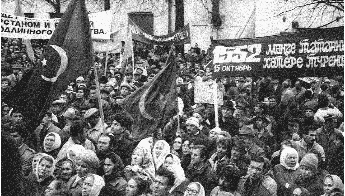 На фото изображены несколько десятков человек с плакатами на митинге